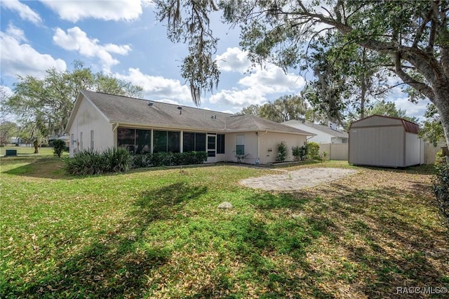 rear view of property with a storage shed, a patio, an outbuilding, fence, and a yard