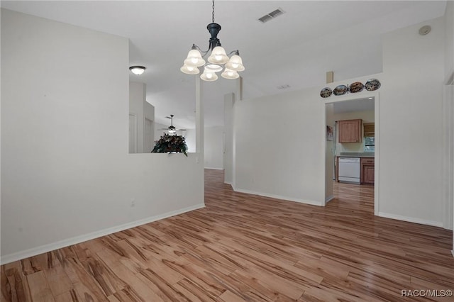 interior space featuring visible vents, ceiling fan with notable chandelier, light wood-style flooring, and baseboards