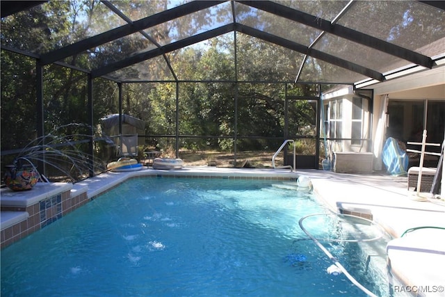 view of swimming pool featuring a patio area and glass enclosure