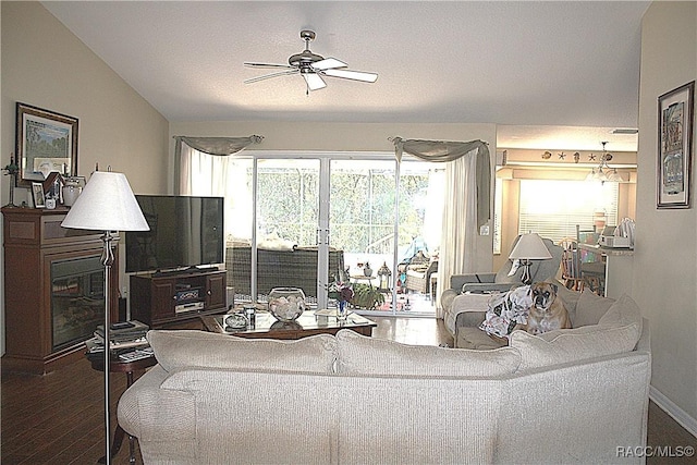 living room with dark wood-type flooring, ceiling fan, and vaulted ceiling