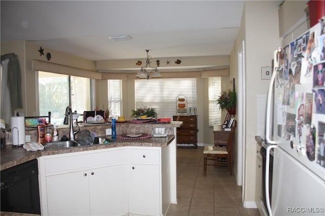 kitchen with sink, dishwasher, white cabinets, dark tile patterned flooring, and white fridge