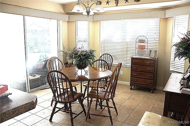 tiled dining space featuring an inviting chandelier