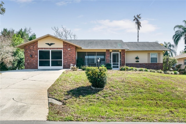 ranch-style home with a front lawn, brick siding, driveway, and an attached garage