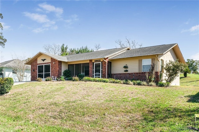 ranch-style home with an attached garage, brick siding, and a front yard