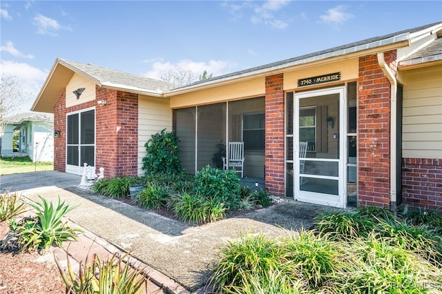 entrance to property featuring brick siding and an attached garage