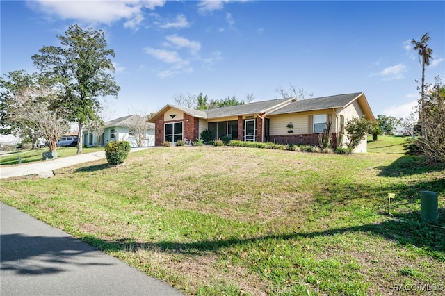 ranch-style home featuring a garage, concrete driveway, brick siding, and a front yard