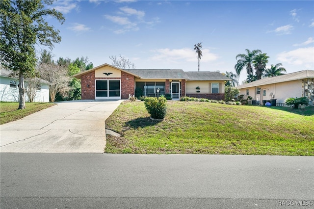 ranch-style house with driveway, a front lawn, and brick siding