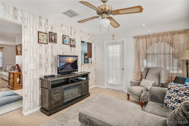 living area with light colored carpet, visible vents, plenty of natural light, and baseboards