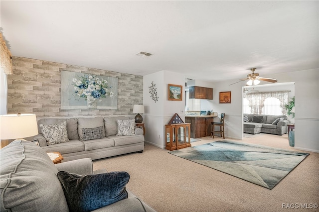 living room featuring light carpet, baseboards, visible vents, and a ceiling fan