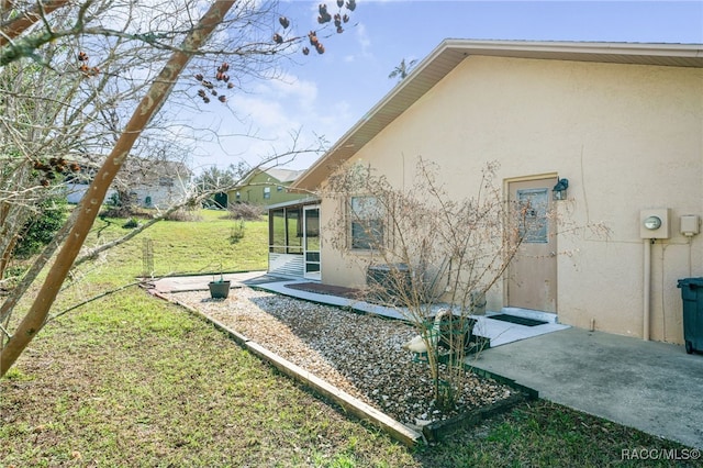 view of yard featuring a sunroom and a patio