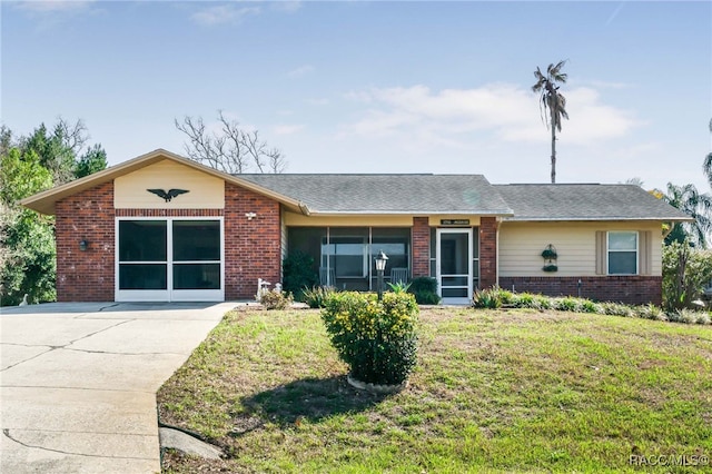 single story home with a garage, brick siding, and a front lawn