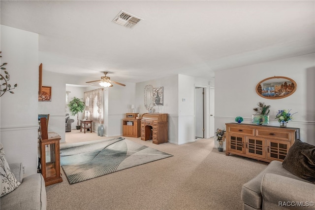 living room featuring visible vents, a ceiling fan, and light colored carpet