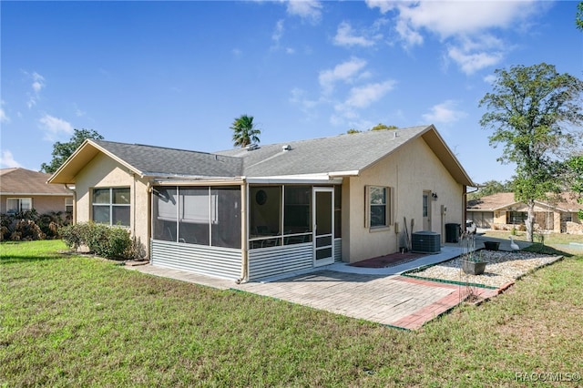 rear view of house featuring a sunroom, a patio area, a lawn, and stucco siding