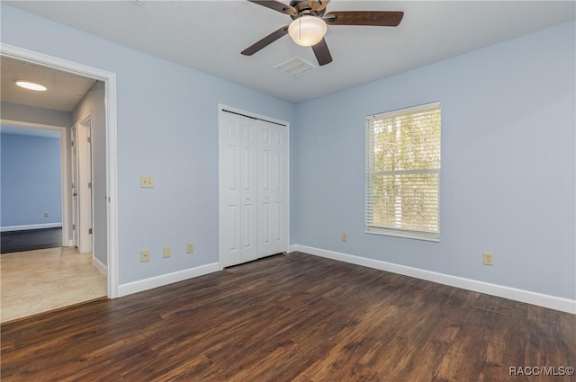 9459 N Camel Dr, Citrus Springs, FL 34434 - unfurnished bedroom with dark wood-style flooring, a closet, and a ceiling fan