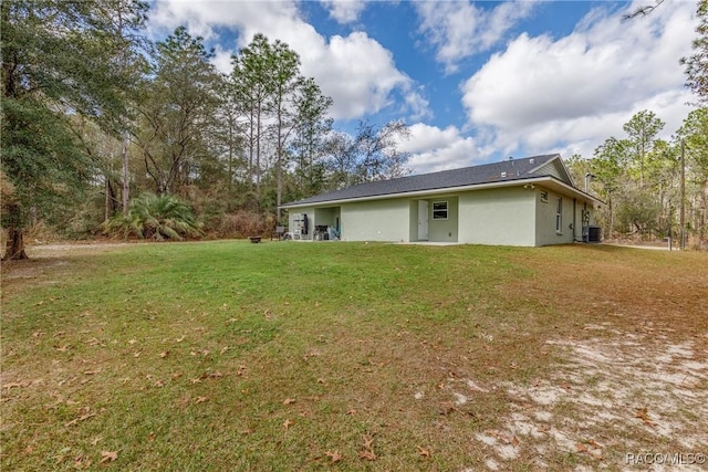 9459 N Camel Dr, Citrus Springs, FL 34434 - back of property with a lawn and stucco siding