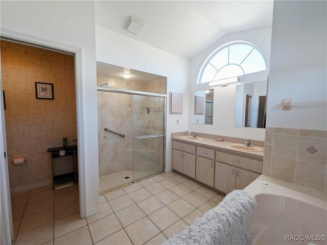 bathroom featuring tile patterned floors, vaulted ceiling, a textured ceiling, vanity, and plus walk in shower