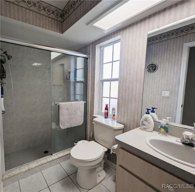 bathroom featuring walk in shower, vanity, toilet, and tile patterned flooring