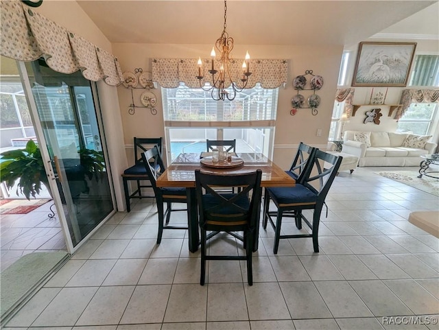 dining space featuring tile patterned flooring, vaulted ceiling, plenty of natural light, and an inviting chandelier