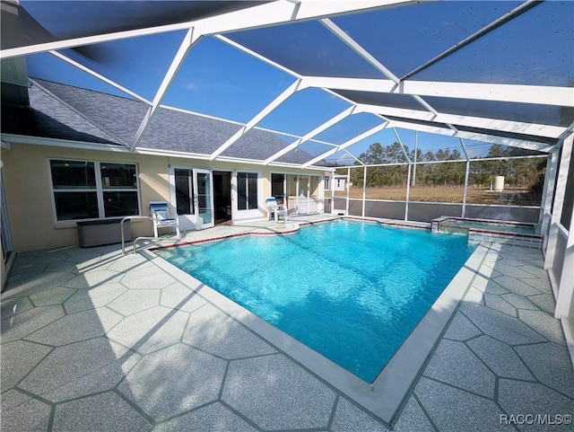 view of pool with an in ground hot tub, a patio, and glass enclosure