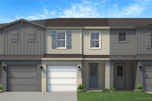 townhome / multi-family property featuring a garage and a front lawn