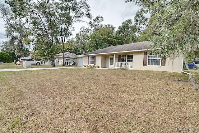 ranch-style home featuring covered porch and a front lawn