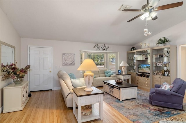 living room featuring ceiling fan, lofted ceiling, and light wood-type flooring