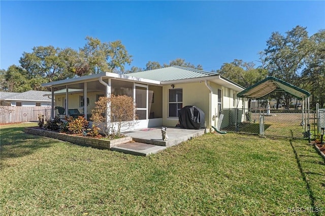 rear view of house featuring a yard and a sunroom