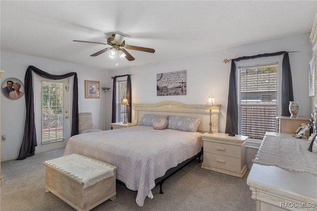 carpeted bedroom featuring multiple windows, access to outside, and ceiling fan