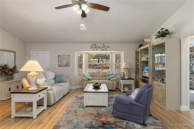 living room with lofted ceiling, ceiling fan, and light wood-type flooring