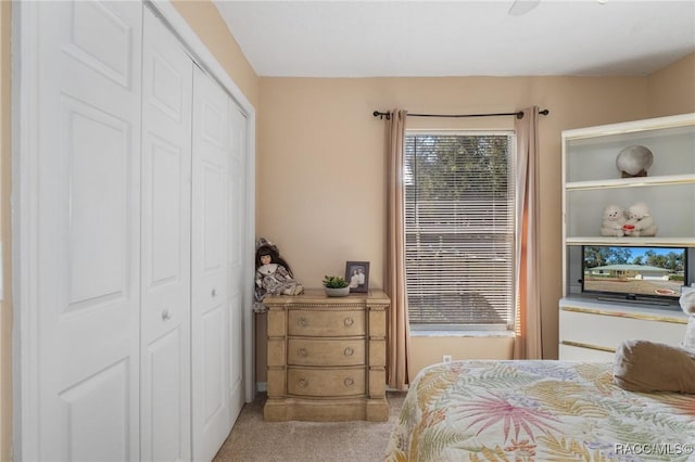 bedroom featuring light carpet, ceiling fan, and a closet