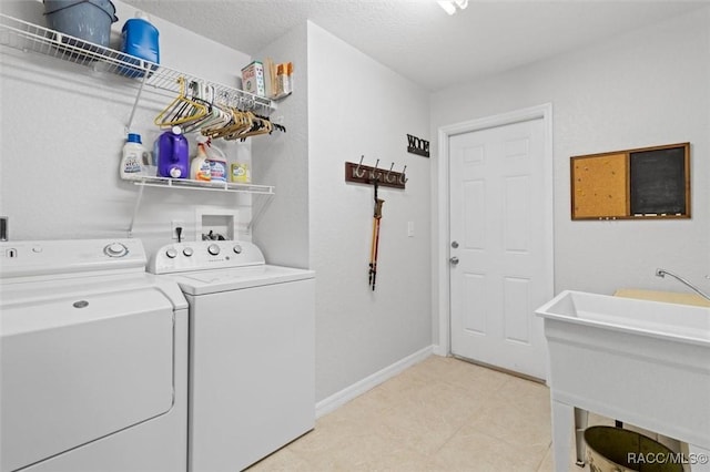 clothes washing area with washer and clothes dryer and sink