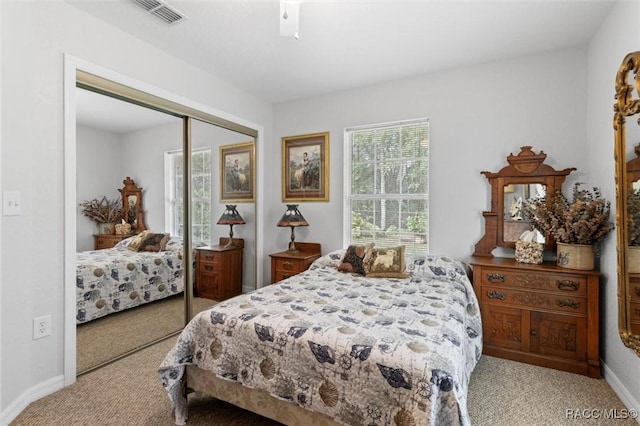 carpeted bedroom featuring ceiling fan and a closet