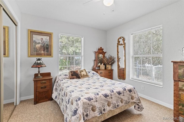 carpeted bedroom with ceiling fan and a closet