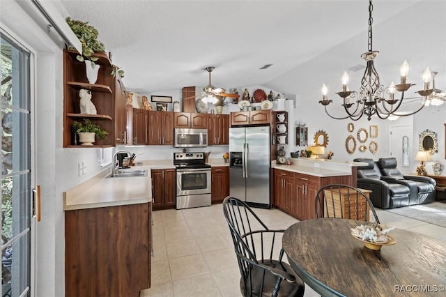 kitchen featuring sink, hanging light fixtures, stainless steel appliances, lofted ceiling, and light tile patterned floors