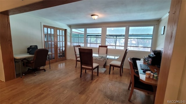 dining room featuring french doors, wood-type flooring, and ornamental molding