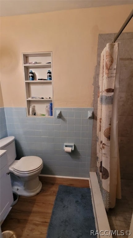 bathroom with toilet, wood-type flooring, tile walls, and walk in shower