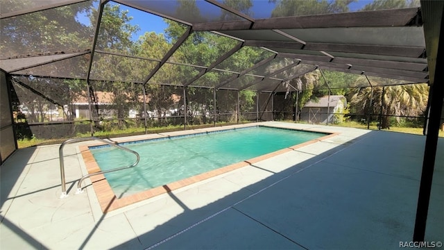 view of pool with glass enclosure and a patio