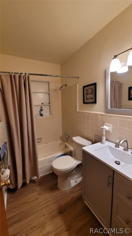 full bathroom featuring vanity, shower / bath combo, hardwood / wood-style flooring, toilet, and tile walls