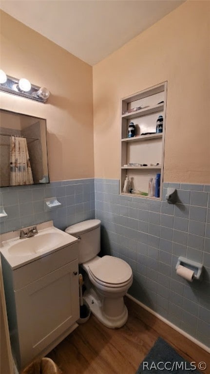 bathroom featuring toilet, vanity, tile walls, and hardwood / wood-style flooring