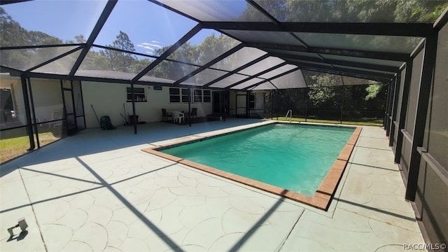 view of swimming pool featuring a lanai and a patio area