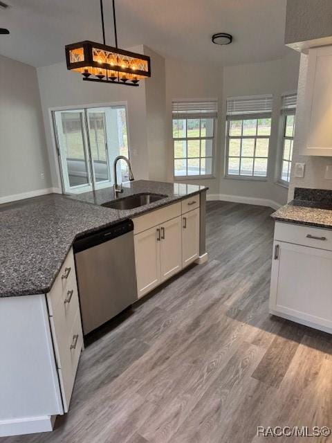 kitchen with stainless steel dishwasher, sink, hanging light fixtures, and white cabinets