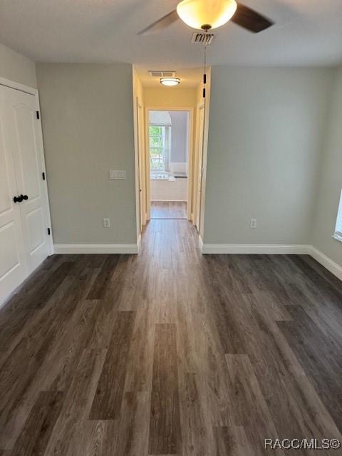 spare room with dark hardwood / wood-style floors and ceiling fan