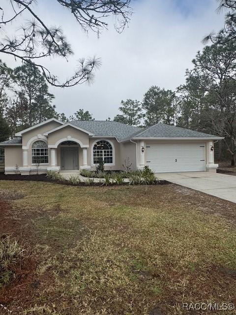 ranch-style house with a garage and a front lawn