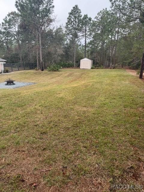 view of yard featuring a storage shed and a fire pit