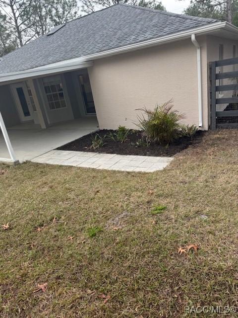 rear view of property with a patio area and a lawn