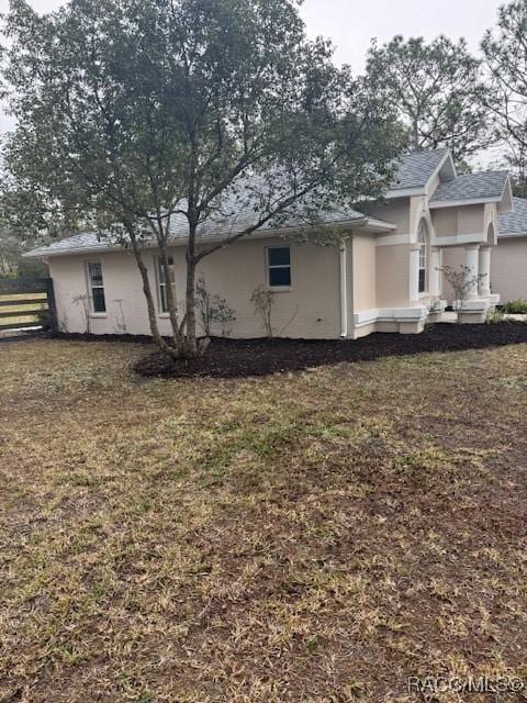 view of side of home with a yard