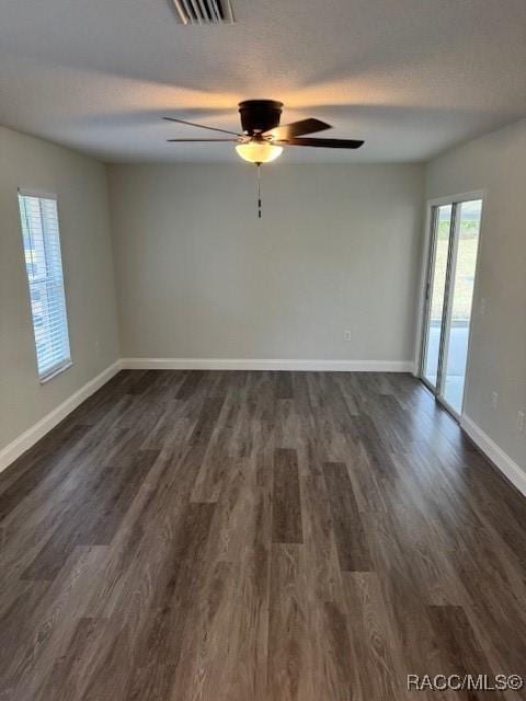 empty room featuring ceiling fan, dark hardwood / wood-style floors, and a textured ceiling