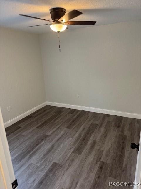 spare room featuring dark hardwood / wood-style flooring, ceiling fan, and a textured ceiling