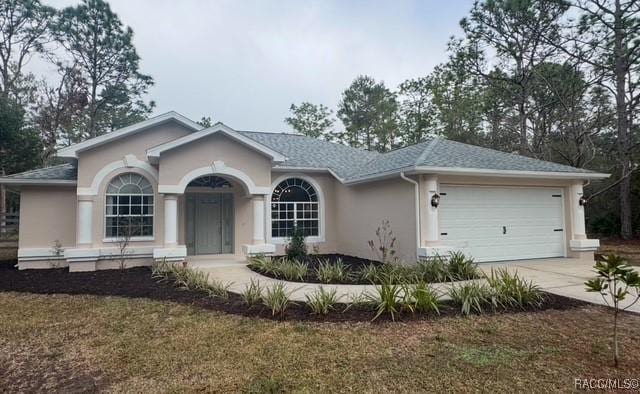 single story home featuring a garage and a front lawn