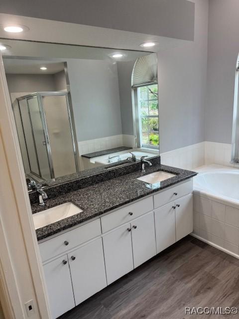 bathroom featuring hardwood / wood-style flooring, vanity, and shower with separate bathtub